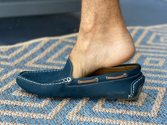 Foot slipping out of a loafer at the heel