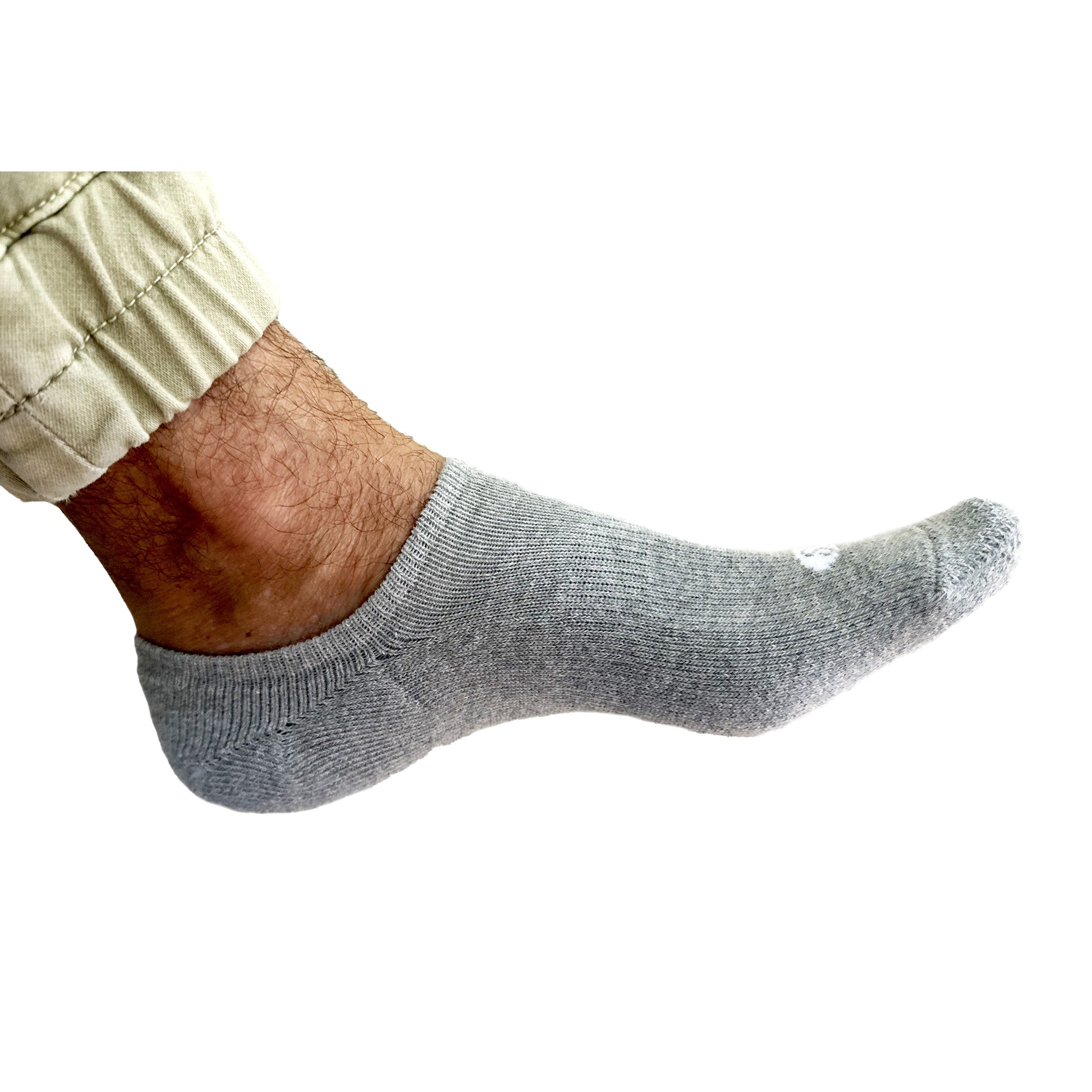 Photograph of a Skinnys Performance padded-heel sock on a man's foot from the side, on a white studio background, revealing low-cut nature of sock